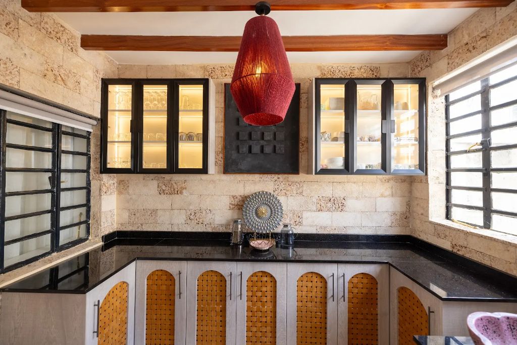 Full corner view of the stone-clad servery with sculptural red pendant