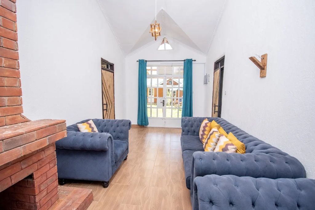 Vaulted guest lounge with brick fireplace and chesterfield sofas