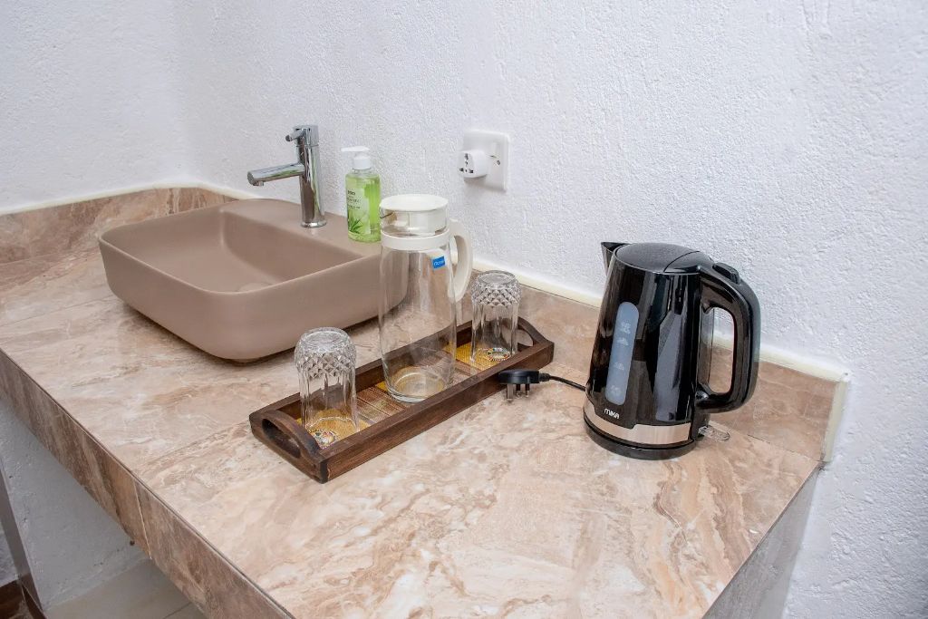 Detail of in-room wash counter with vessel basin and kettle