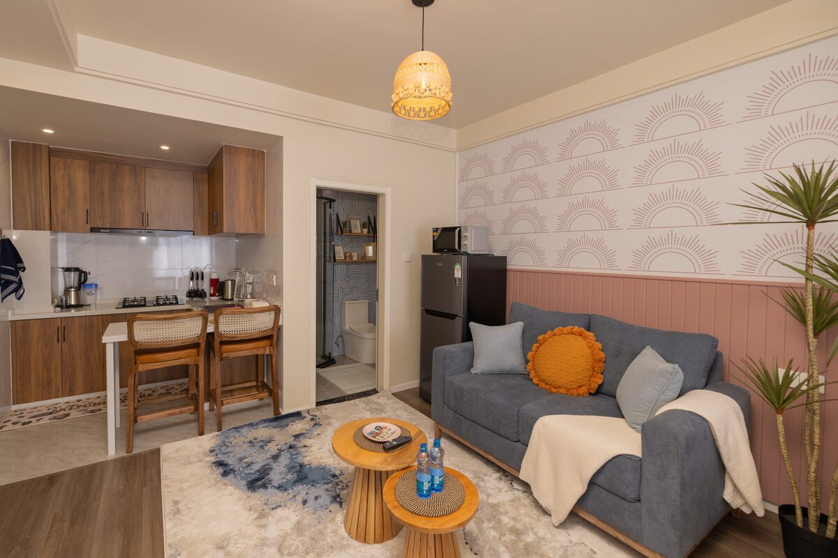 Open-plan Kilimani studio living and kitchen area with sunburst wallpaper feature wall
