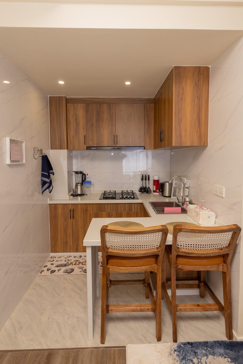 Compact galley kitchen with rattan breakfast bar stools