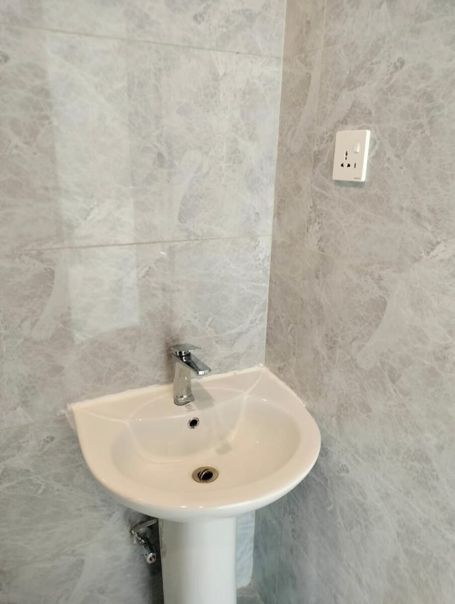 Before: gray marble-tile close-up with pedestal sink