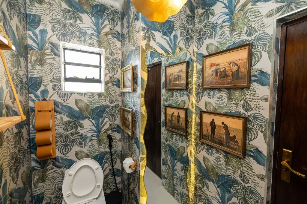 Botanical wallpaper hallway with gold-framed gallery artwork