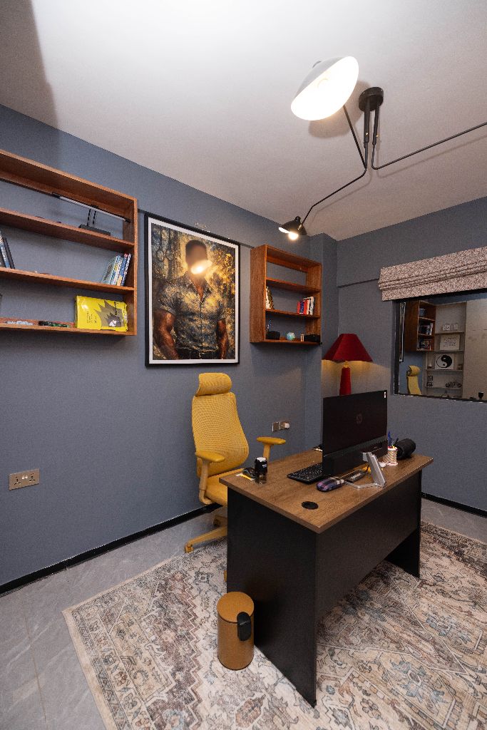 Home office with mustard ergonomic chair and gallery shelving, Nairobi family residence