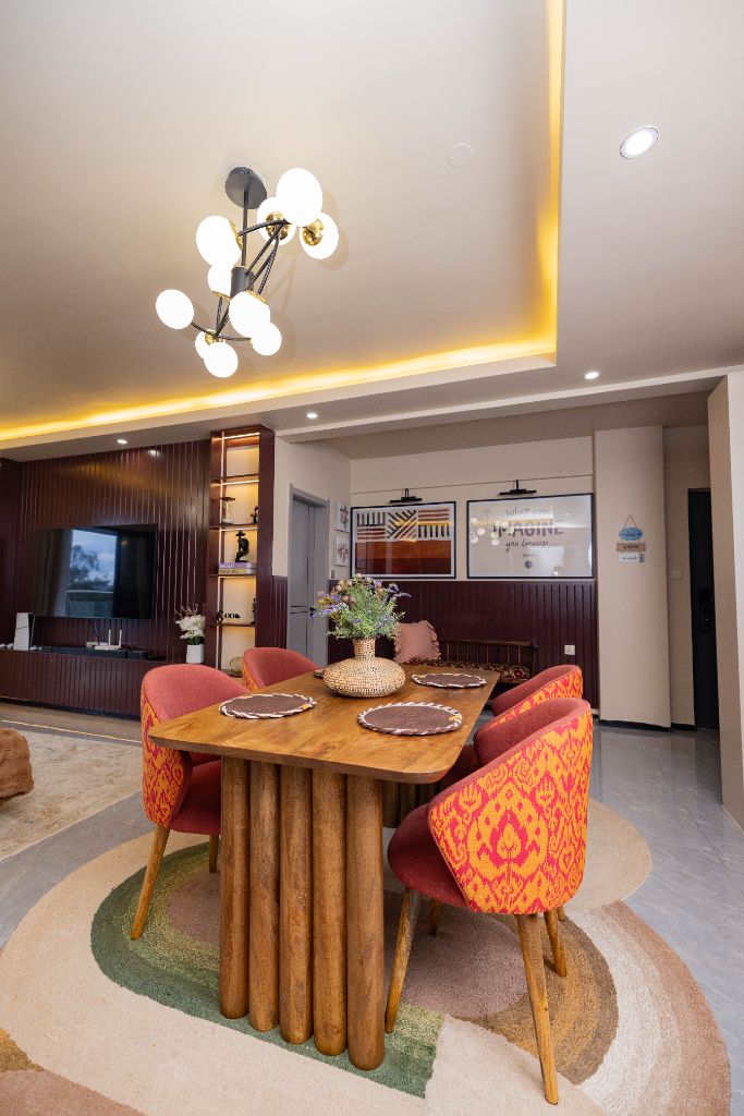Sculptural dining table with patterned chairs and pendant lighting, Nairobi family residence