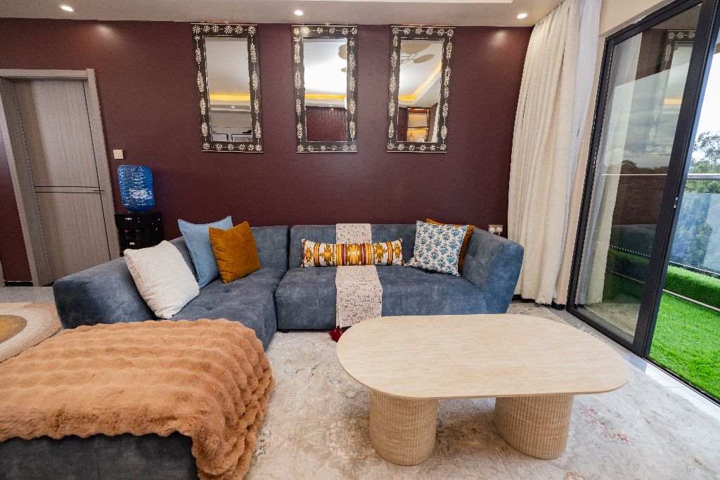 Living room seating area with mirrored accent wall, Nairobi family residence